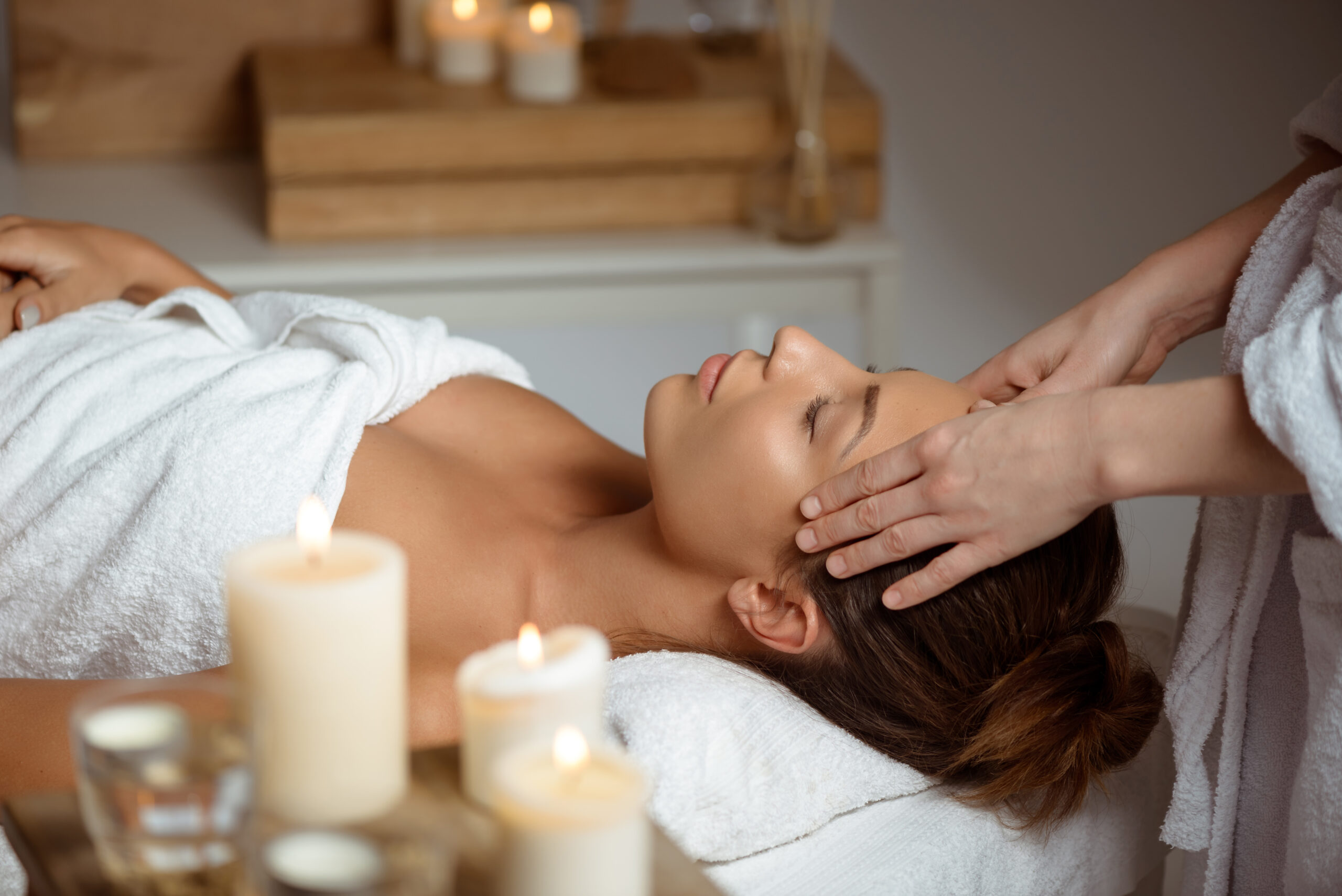 The image shows a woman giving a facial massage.